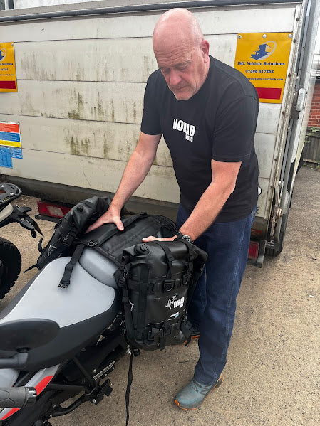 Man fitting NOMAD MOTO bag on motorcycle seat