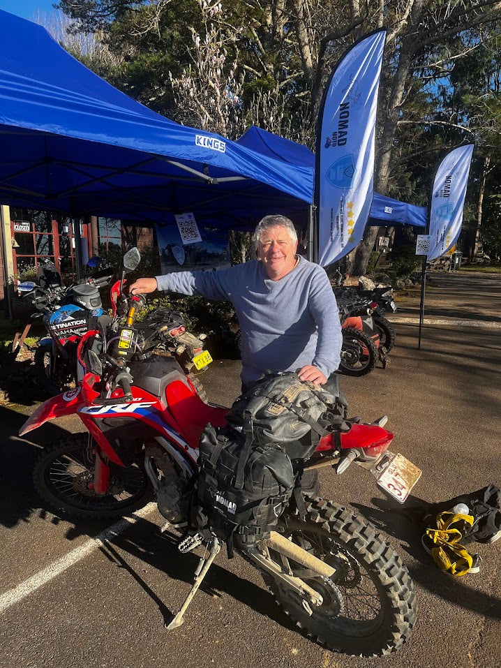 Man standing with red adventure motorcycle