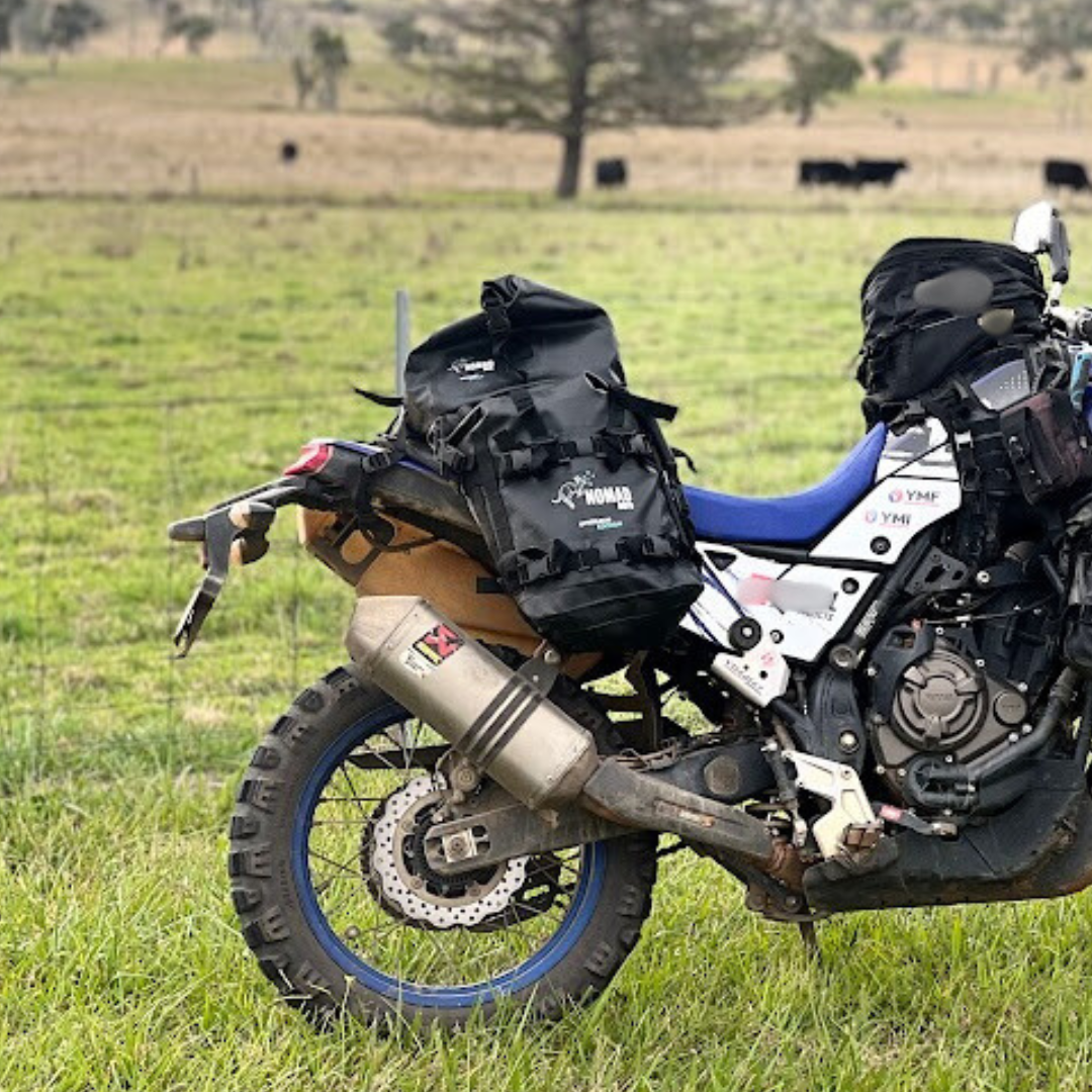 ADV motorcycle with soft luggage bags parked on the grass