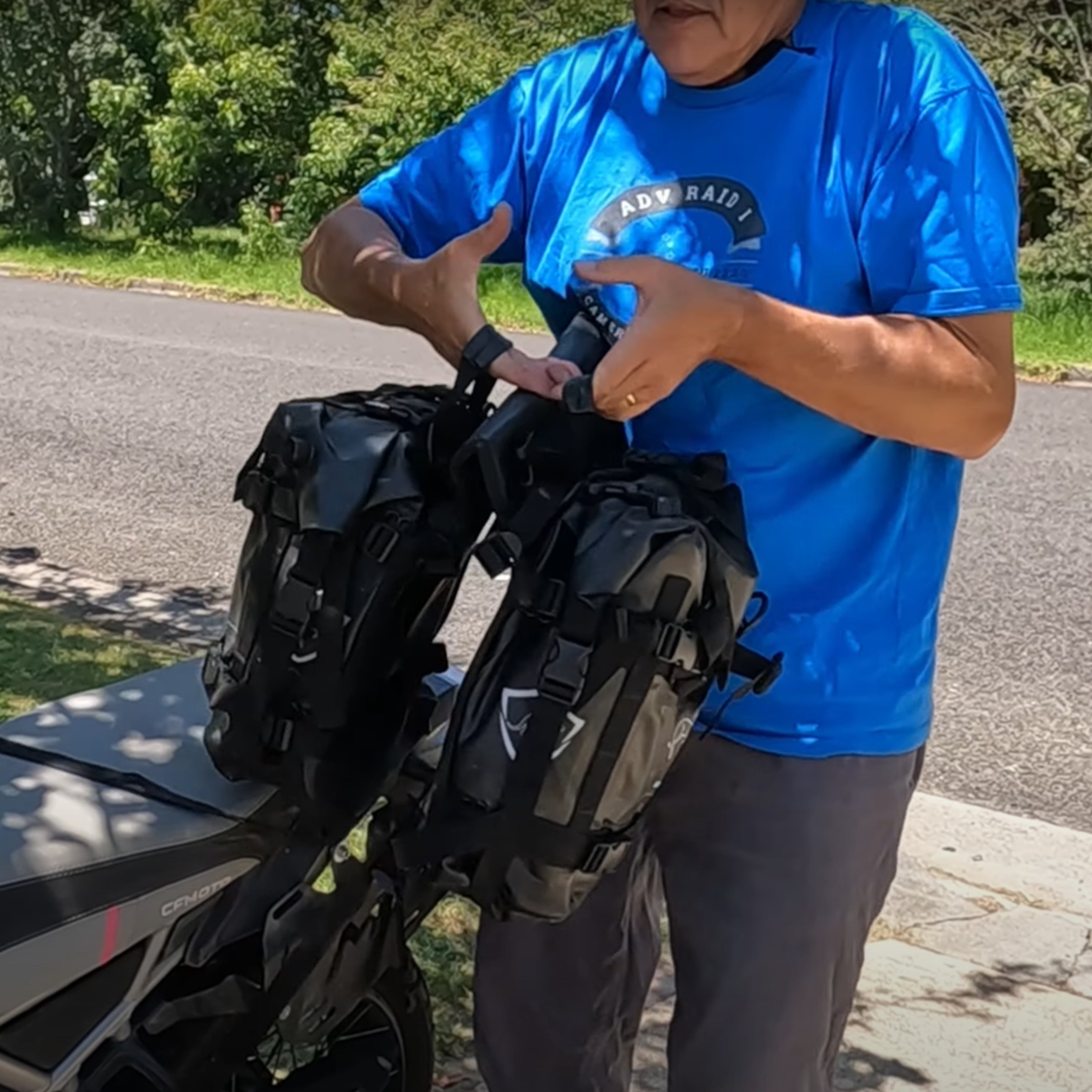 Man securing waterproof luggage on motorcycle